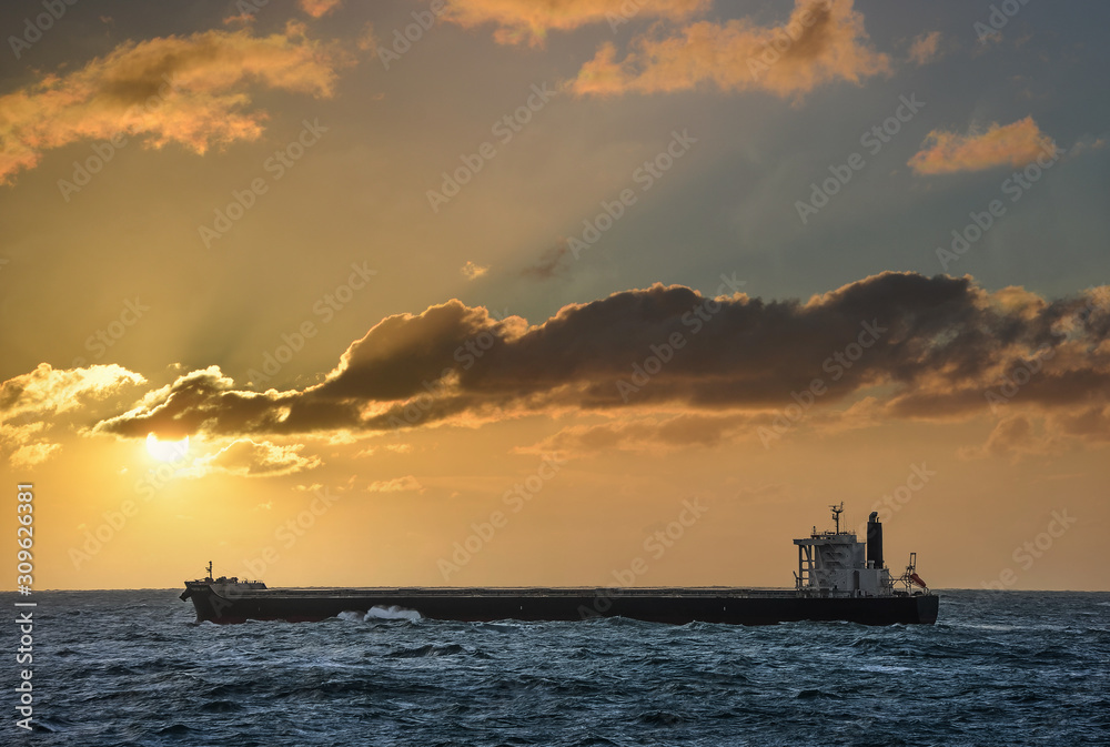 Obraz premium cago sailing at sea at sunset