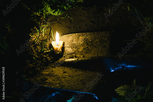 dirty old shovel in dark trench. Digging grave by candlelight. Mystical night scene
