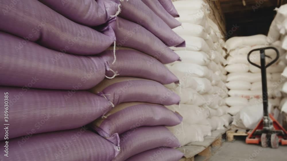 Bags with flour in warehouse of flour factory. Flour stock. Mill