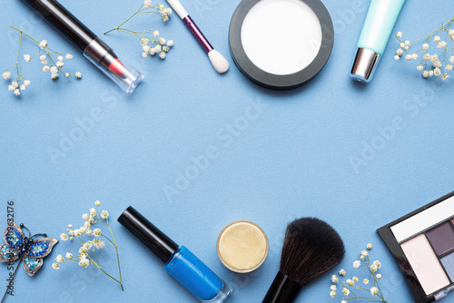 Make up beauty accessories on blue flat lay background with copy space.