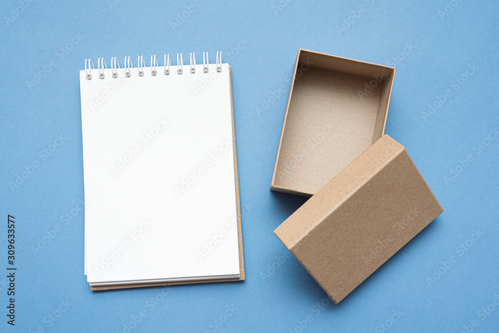 Brown cardboard box and blank on blue background. Brown cardboard box and blank on blue background.