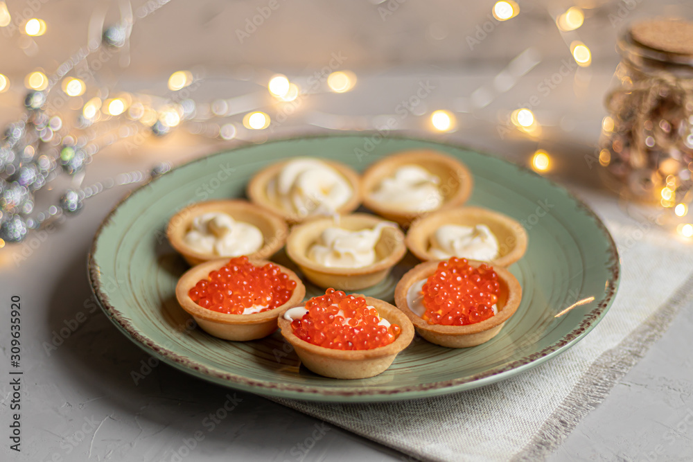Tartlets with soft cheese, shrimp and red caviar. Holiday dish. On a green plate. Tartlets with soft cheese, shrimp and red caviar. Holiday dish. On a green plate.