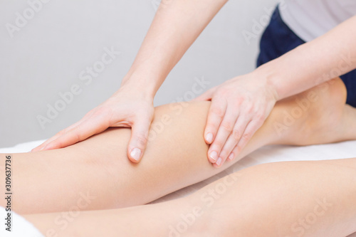 Young woman having feet massage in beauty salon, close up view