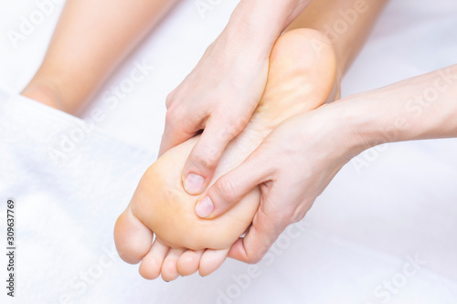 Young woman having feet massage in beauty salon, close up view © Elena