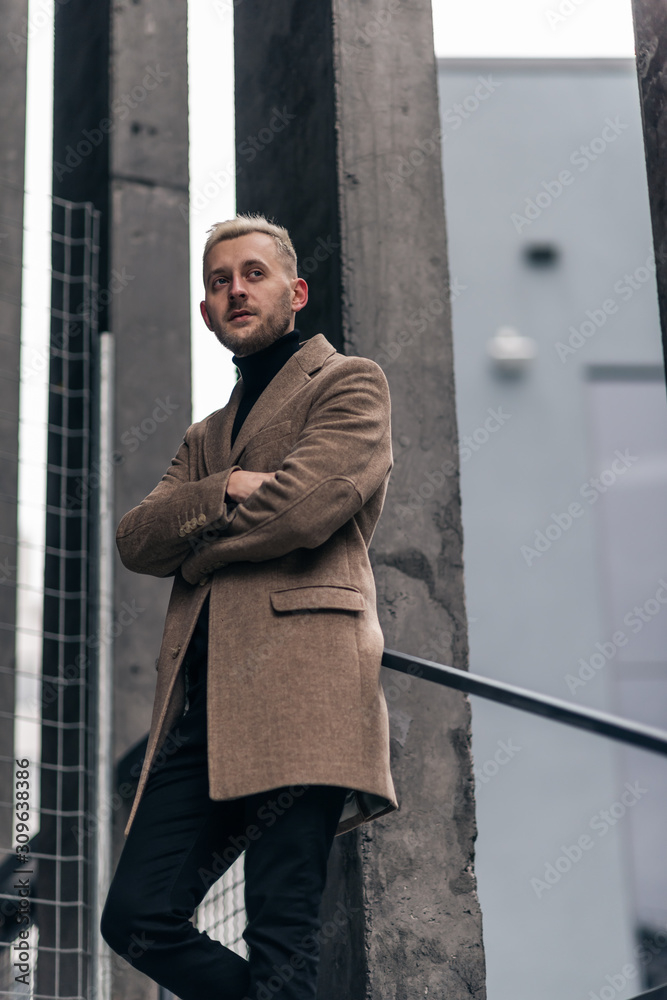 Selective focus of handsome businessman standing in beige coat. Selective focus of handsome businessman standing in beige coat.
