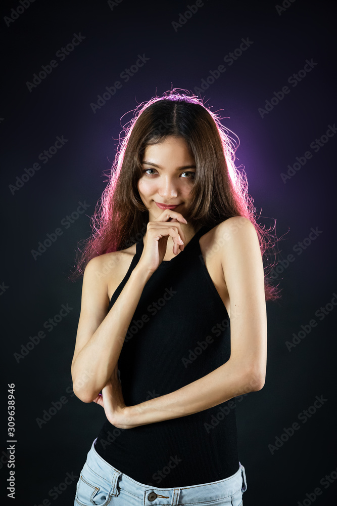 Young woman in black off shoulder tops posing confident, like have something funny with purple light on black background