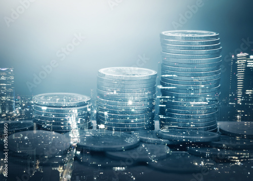 Double exposure of city and stack of coins for finance and banking concept