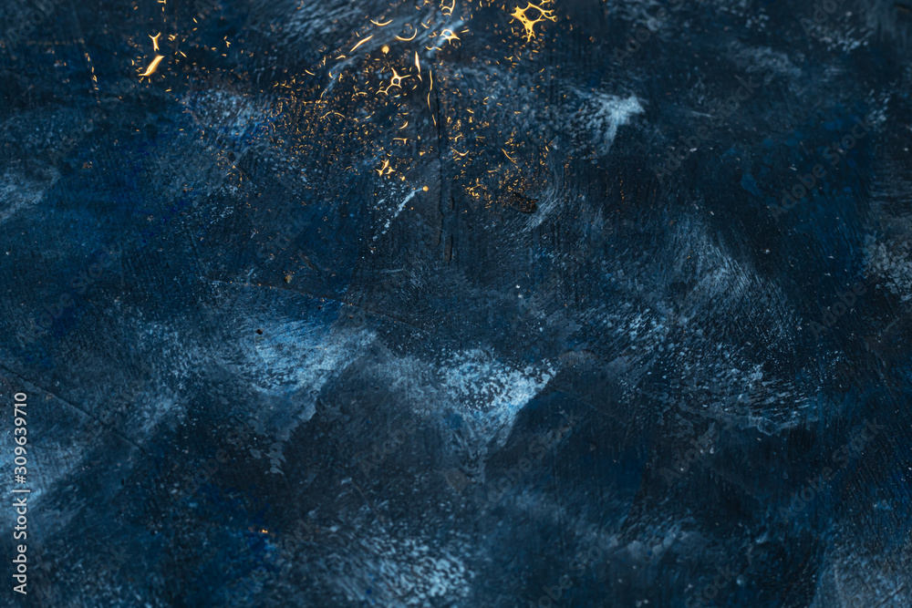 Obraz premium Deep blue with gold splashes over concrete.