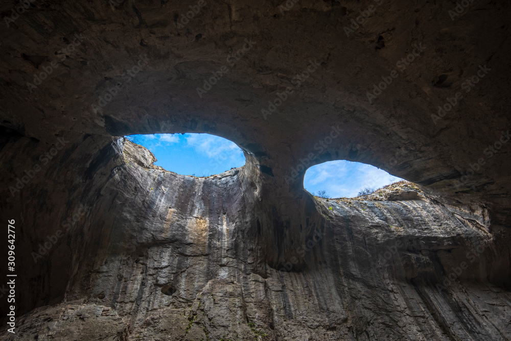 Panoramic view of Prohodna cave also known as God's eyes near Karlukovo village, Bulgaria. Colorful cave formation with giant entrance. Panorama