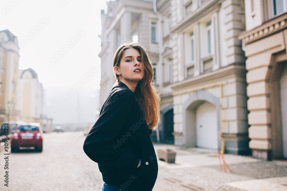 © GalakticDreamer - Portrait of beautiful female student in black jacket enjoying free time while walking across city and looking at camera,  trendy dressed street style and fashionable hipster girl strolling outdoors
