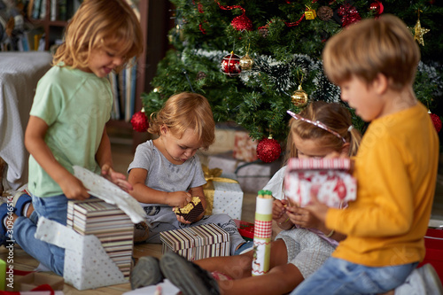Happy family - children and Christmas gifts on floor at home.