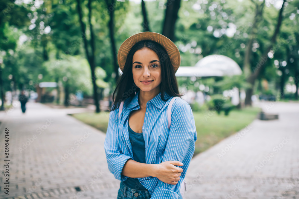 Half length portrait of attractive trendy dressed woman posing outdoors and looking at camera during free time for recreating in public park, beautiful hipster girl in stylish hat enjoying leisure Half length portrait of attractive trendy dressed woman posing outdoors and looking at camera during free time for recreating in public park, beautiful hipster girl in stylish hat enjoying leisure