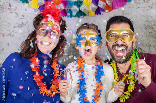 Happy family with masks celebrating Carnival