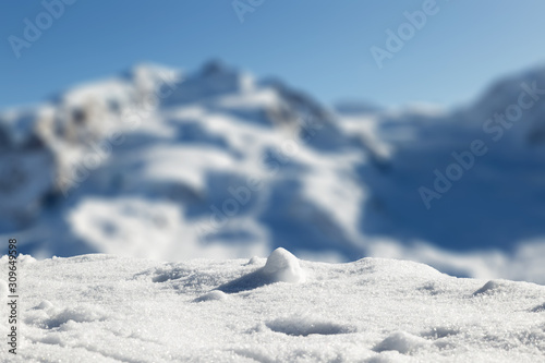 Foreground with fresh snow, with Swiss mountains in the blurred background.
