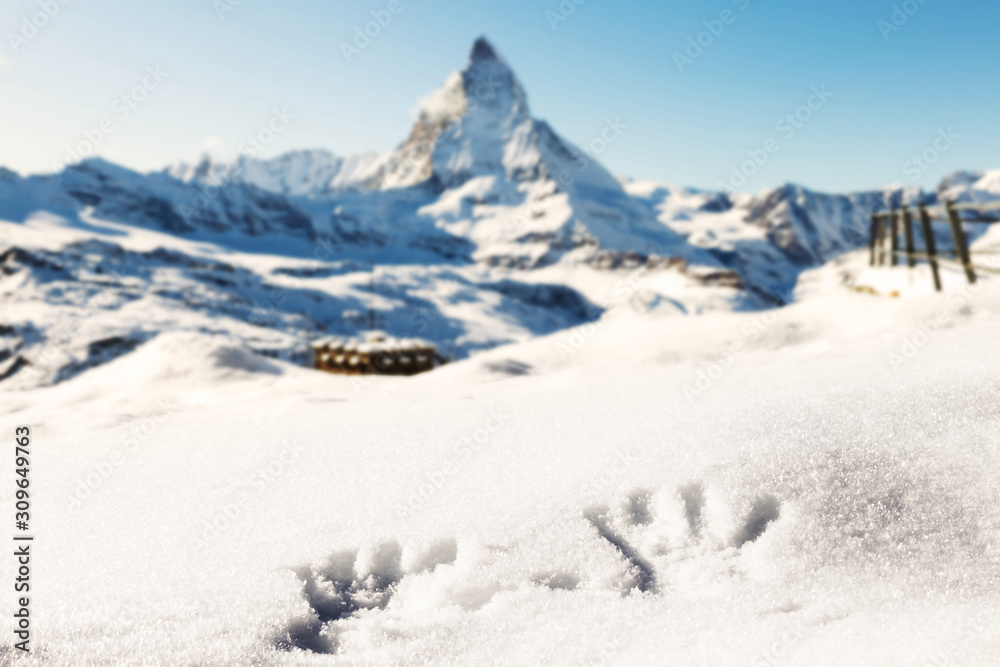 Hands shapes on fresh snow, with the background of the mountains and the Matterhorn.