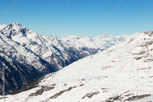 Panorama with snowy mountains, blue sky. Alps.