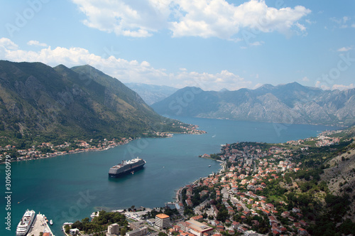 Landscape from the mountains to the bay in the Adriatic Sea. Panorama of the old town on the shore with a cruise ship at sea.