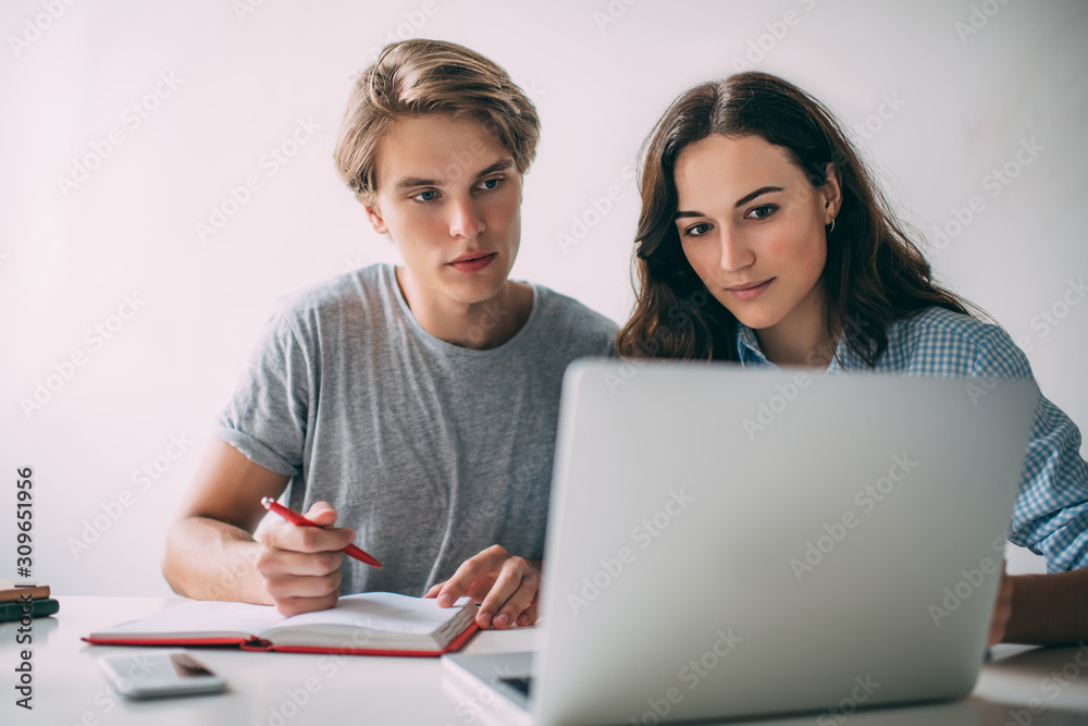 Skilled male and female students collaborating on college course work using university website with information for research, smart man and woman watching tutorial webinar during e learning indoors Skilled male and female students collaborating on college course work using university website with information for research, smart man and woman watching tutorial webinar during e learning indoors