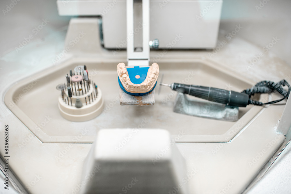 Artificial jaw for implants modeling with set of dental burs at the working place of dental technician in the laboratory