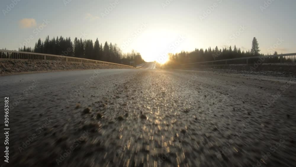 The car goes at high speed on a winter track at sunset.Asphalt road.Travel by car. The car goes at high speed on a winter track at sunset.Asphalt road.Travel by car.