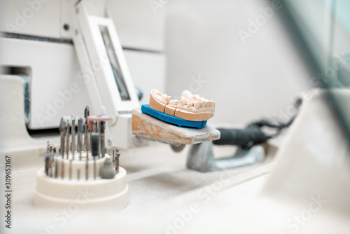 Artificial jaw for implants modeling with set of dental burs at the working place of dental technician in the laboratory