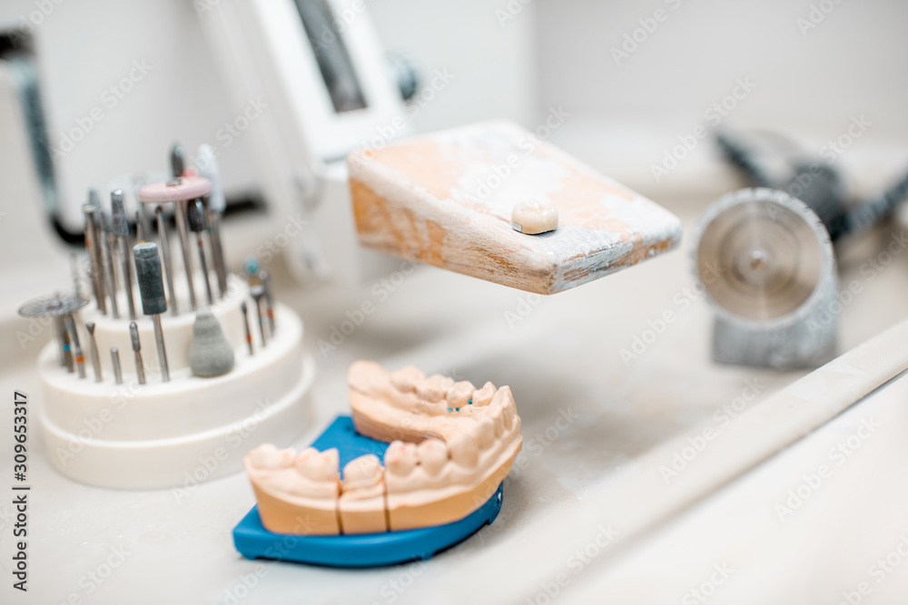 Artificial jaw for implants modeling with set of dental burs at the working place of dental technician in the laboratory Artificial jaw for implants modeling with set of dental burs at the working place of dental technician in the laboratory