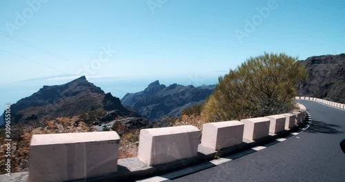 Driving a car on bluff dangerous highway in the mountains landscape. Excting road travel near Masca gorge on Tenerife in sunny summer season. photo