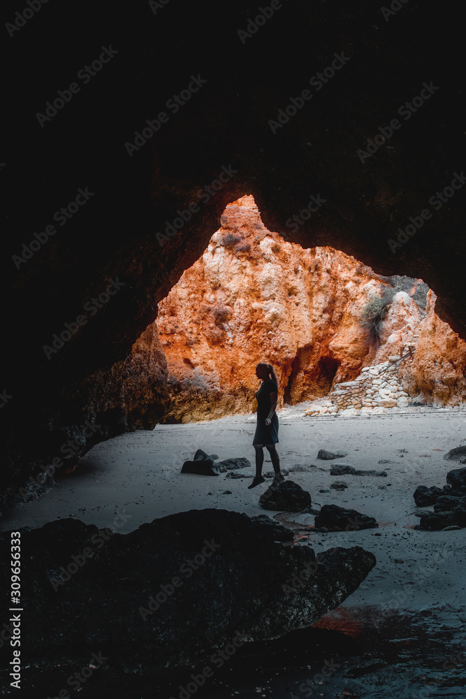 A girl standing in a cave at the algarve in portugal
