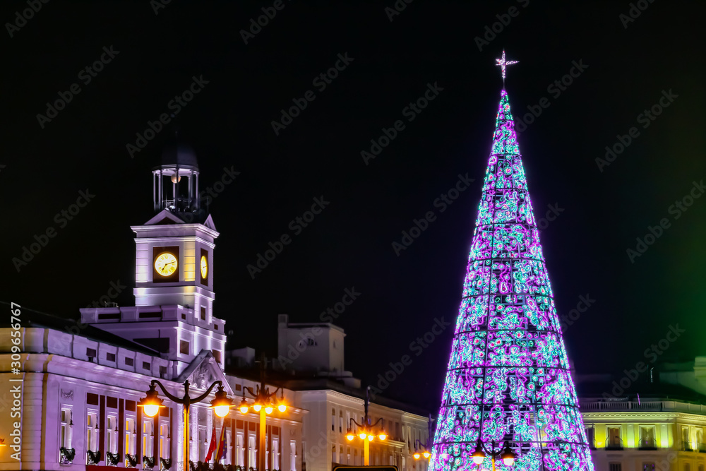 Árbol de navidad iluminado y Puerta del Sol en Madrid, España.