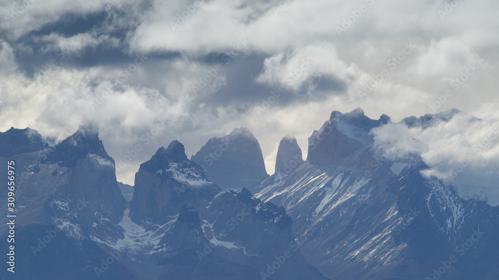 The peaks of the Torres del Paine mountains that emerge from the clouds, Torres del Paine National Park, Chile