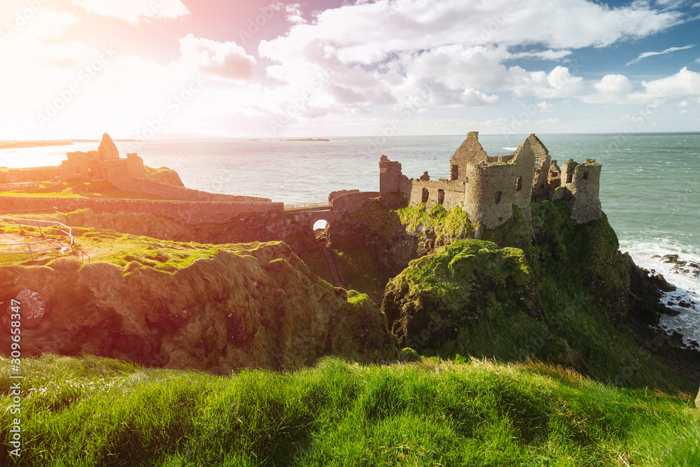 Dunluce Castle, Antrim, Northern Ireland during sunny day with semi cloudy sky