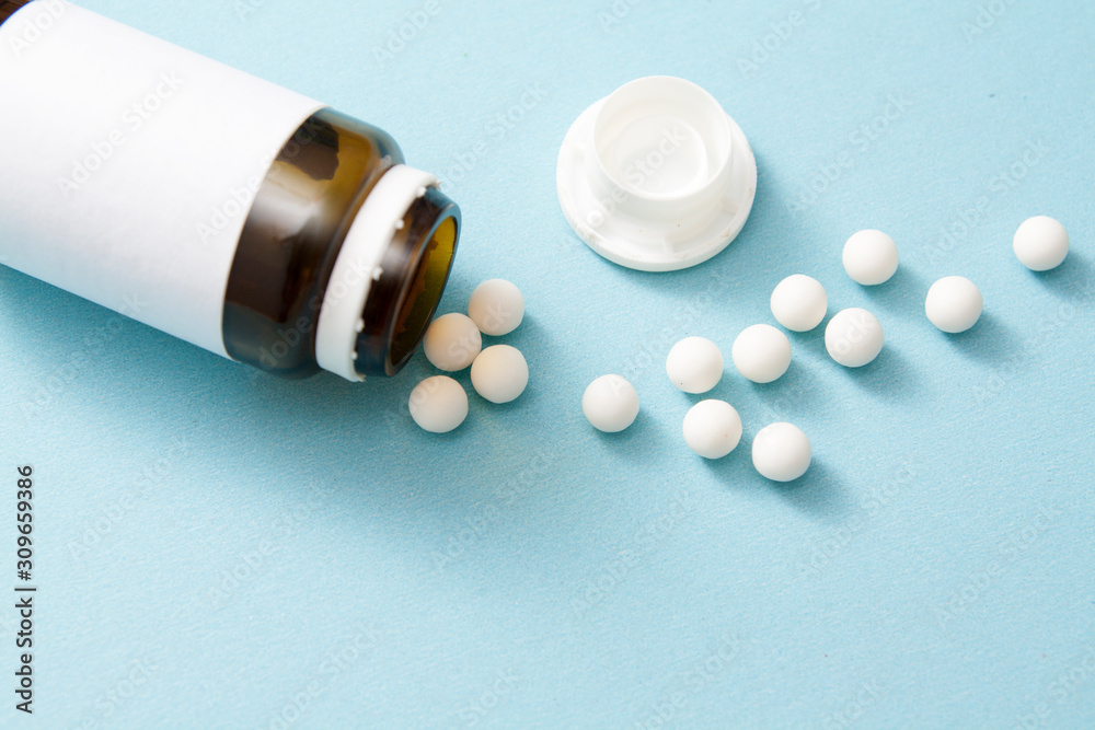 Pills poured from a jar on a blue background. Medical concept, treatment, health Pills poured from a jar on a blue background. Medical concept, treatment, health