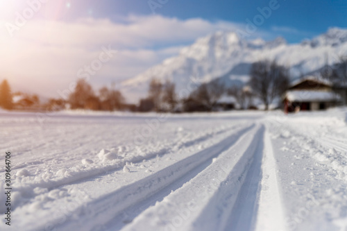 Cross-country skiing in Austria: Slope, fresh white powder snow and mountains, blurry background