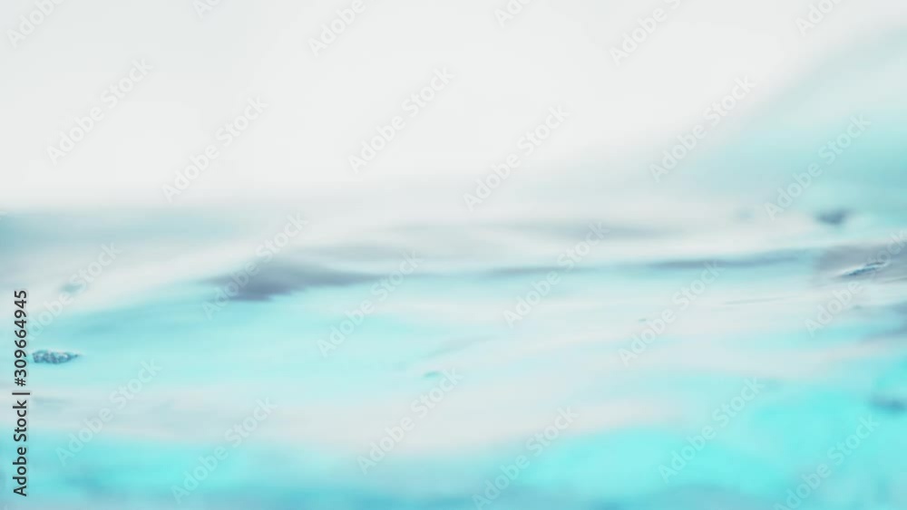 The clean water surface in slow motion fills the screen with water splashing shop the water drop and waving liquid surface with an air bubble. 1080p 29.97fps The clean water surface in slow motion fills the screen with water splashing shop the water drop and waving liquid surface with an air bubble. 1080p 29.97fps
