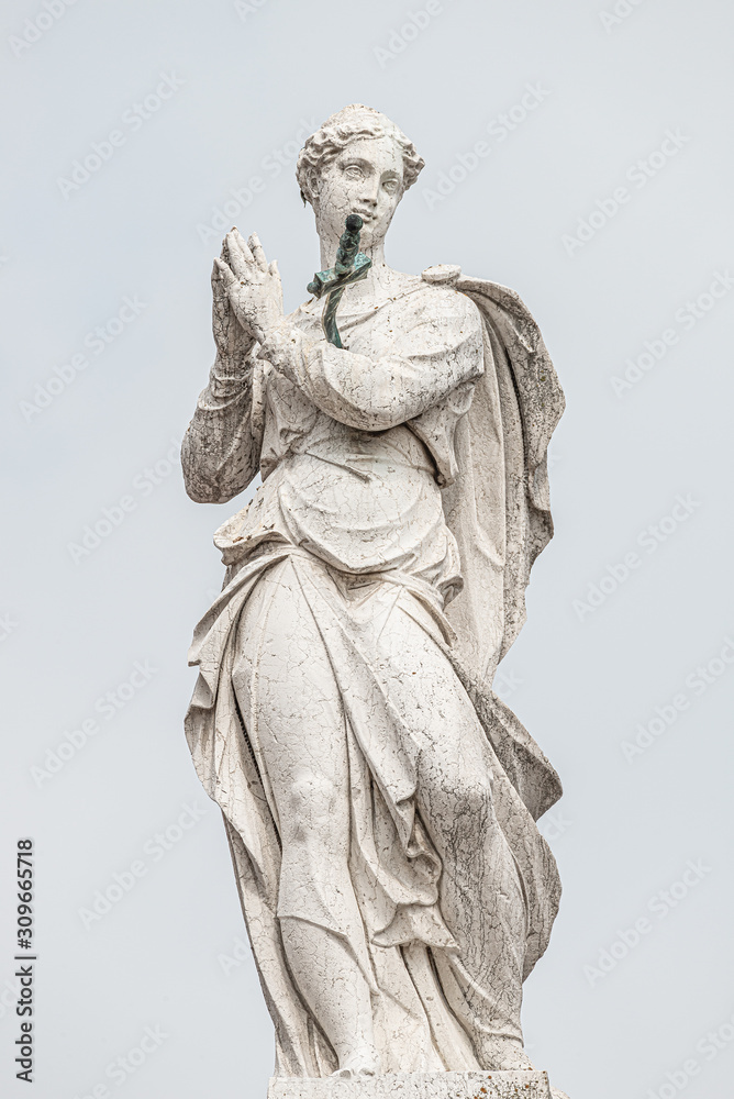 Ancient aged sculpture of beautiful praying Angel with wings at roof of Santa Maria Assunta Jesuits Church in Venice, Italy, details, closeup