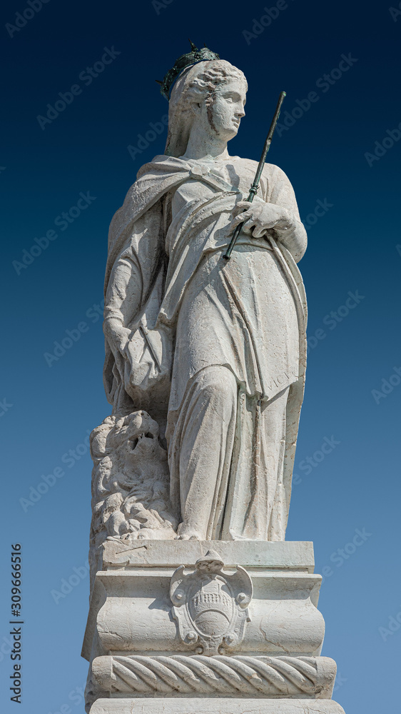 Ancient roof statue of a beautiful Renaissance Era Royal woman in Venice at blue sky background, Italy, closeup, details