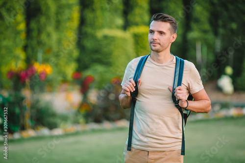 Young man hiking smiling happy portrait. Male hiker walking in the city © travnikovstudio