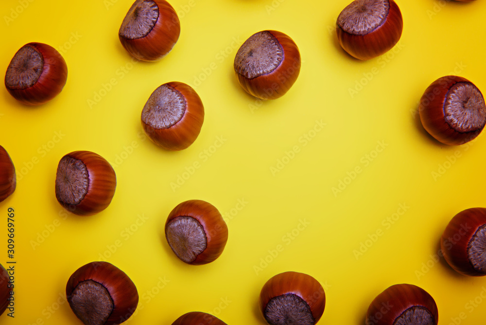 Unpeeled hazelnuts on a yellow background. Flatley. Copy space. Unpeeled hazelnuts on a yellow background. Flatley. Copy space.