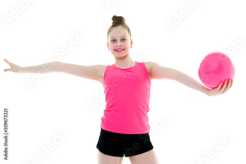 little girl is engaged in fitness with a ball.