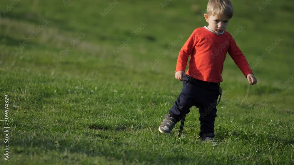 Funny blond hair child play on grass, play and sing Funny blond hair child play on grass, play and sing