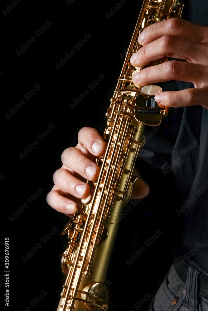 Fototapeta premium soprano saxophone in hands on a black background
