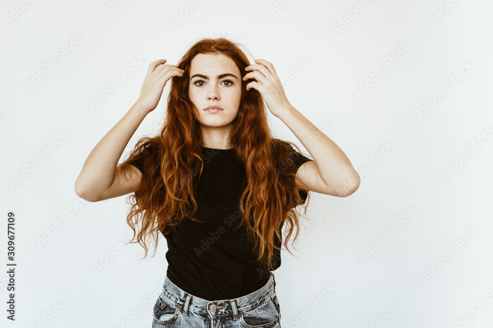 girl with a serious face straightens her luxurious hair with her hands girl with a serious face straightens her luxurious hair with her hands