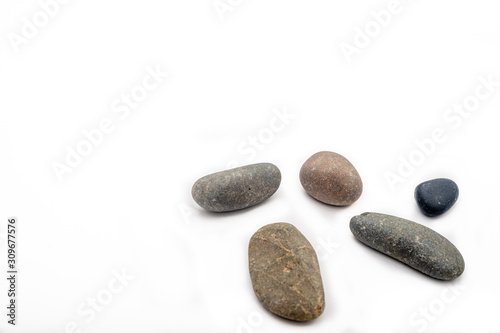 Scattered sea pebbles. Smooth gray and black stones isolated on white background. Top view