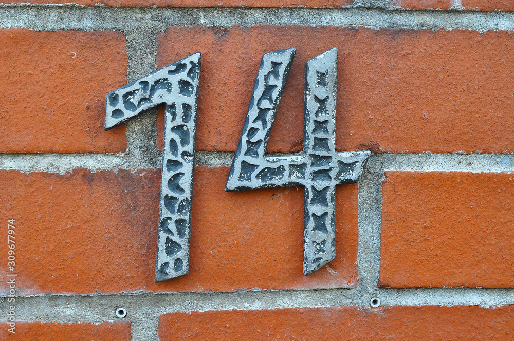 Obraz premium A house number plaque, showing the number fourteen (14)