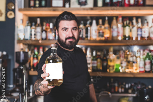 Hipster bartender offers to drink a soft drink  mock up on the label of the bottle. Concept of invitation to drink alcohol