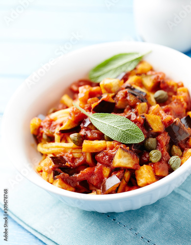 Pasta with vegetable sauce and fresh herbst. Bright background.