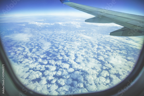 Airplane flying above clouds. The view through the porthole