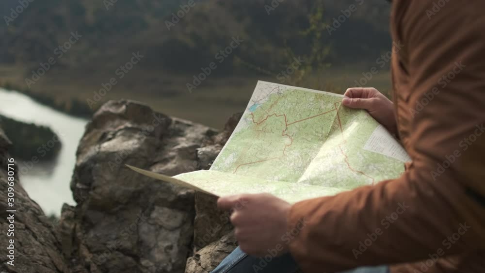 Close up of hands of hiker tourist traveler man looking for map route, traveling on mountain. Active lifestyle hiking enjoying vacation travel tourism backpacking adventure landscape nature 4 K slowmo