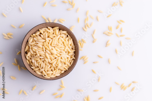 Orzo pasta, isolated on white background. Italian orzo pasta shaped like grains of rice, copy space, soft light