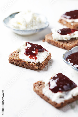 Sandwiches with cream cheese and jam. Whitre wooden background. 